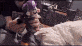 a person is holding a stuffed animal in their hands while playing a video game .