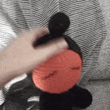 a person is holding a stuffed animal with a red nose