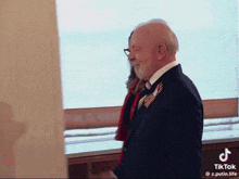 a man in a suit and tie is standing next to a woman in a red jacket .