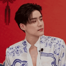 a man wearing a blue and white floral shirt with a microphone