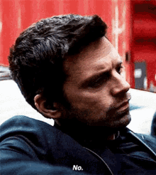 a man with a beard is sitting in a car and talking to another man .