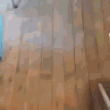 a blurred image of a wooden floor with a chair in the background