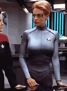 a woman in a star trek uniform has a star on her chest
