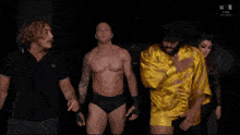 a group of wrestlers are standing in front of a sign that says w in the corner