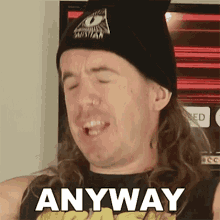 a man with long hair and a beanie is making a funny face and saying anyway .