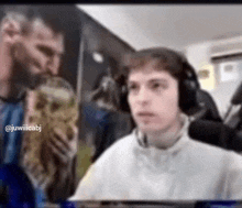 a man wearing headphones is holding a trophy in front of another man