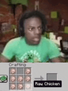 a man in a green shirt is sitting at a table in front of a crafting table .