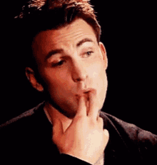 a man is covering his mouth with his hand .