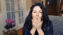 a woman blowing a kiss with a love sign in the background