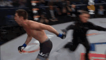 a man in a boxing ring wearing shorts with the letter t on them