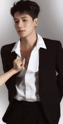 a man in a suit and white shirt has a tattoo on his chest that says ' i love you '