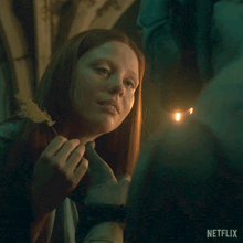 a netflix ad shows a woman holding a leaf and a candle
