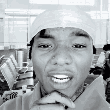 a young man with a bandage on his head is smiling