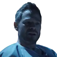 a close up of a man 's face with a blue shirt on