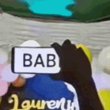 a person is holding a sign that says bab on it