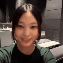 a woman in a green shirt is smiling in a room