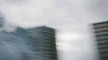 a blurry photo of a city skyline with a cloudy sky in the background