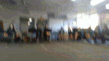 a blurred image of people standing in a room