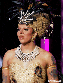 a woman wearing a feathered headdress and a necklace with the letters t4yce tumblr on the bottom