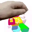 a hand is reaching for a stack of blocks .