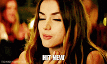 a woman with her eyes closed and the words hit new written on her face