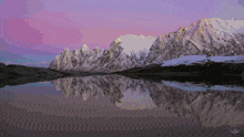 mountains are reflected in a lake at sunset