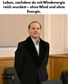 a man in a suit stands in front of a sign that says energie
