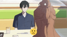 a man and woman sit at a table with a sad face on it