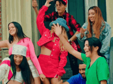 a woman in a red jacket is surrounded by a group of young people