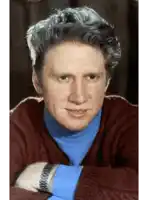 a man wearing a blue turtleneck and a watch
