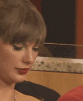 a close up of a woman 's face with red lipstick and a necklace