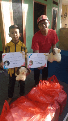 a man in a red adidas shirt stands next to a boy holding a certificate and a stuffed animal