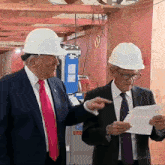 two men wearing hard hats are standing in front of a building that says 270 on it