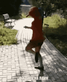 a woman in a red dress is dancing on a brick sidewalk with russian writing on the bottom