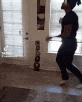 a man is jumping in the air in a living room while holding a spoon .