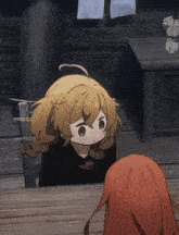 a girl with blonde hair is sitting at a wooden table with another girl