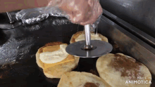 a person is cutting a biscuit with a pizza cutter and the words made in animotica are on the bottom