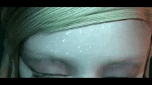 a close up of a person 's face with their eyes closed and snow on it