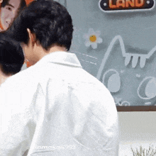 a man is standing in front of a sign that says land