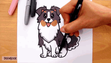 a person is drawing a dog on a piece of paper that says drawbook on the bottom