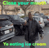 a man is eating ice cream in a parking lot with the words close your mouth ye eating ice cream below him