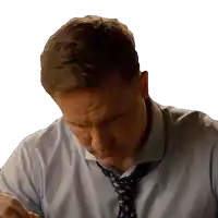 a man in a blue shirt and tie looks down at something