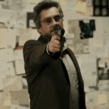 a man in a suit is pointing a gun at something