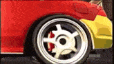 a close up of a red car with a yellow fender