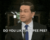 a man in a suit and tie is standing in front of a microphone .