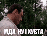 a man in a white shirt is reading a newspaper with a caption that says mda , hy i xusta