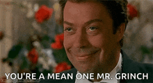 a man in a tuxedo and bow tie is smiling and saying you 're a mean one mr. grinch .