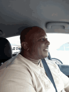 a man wearing a shirt that says ' abercrombie & fitch ' on it sits in a car