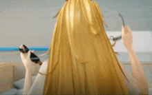 a woman with long blonde hair is brushing her hair with a comb