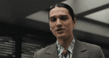 a man with long hair wearing a suit and a tie